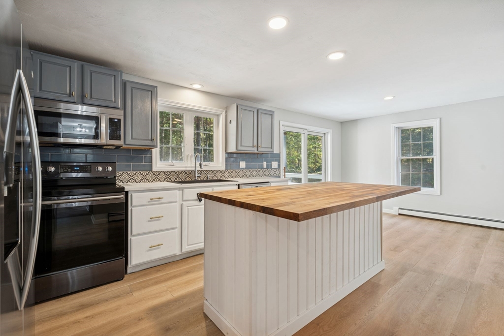16 Captain Danforth Lane Amherst, NH 03031 - Photo 8 of 30 a kitchen with stainless steel appliances granite countertop a stove a sink dishwasher a refrigerator and a oven with wooden floors