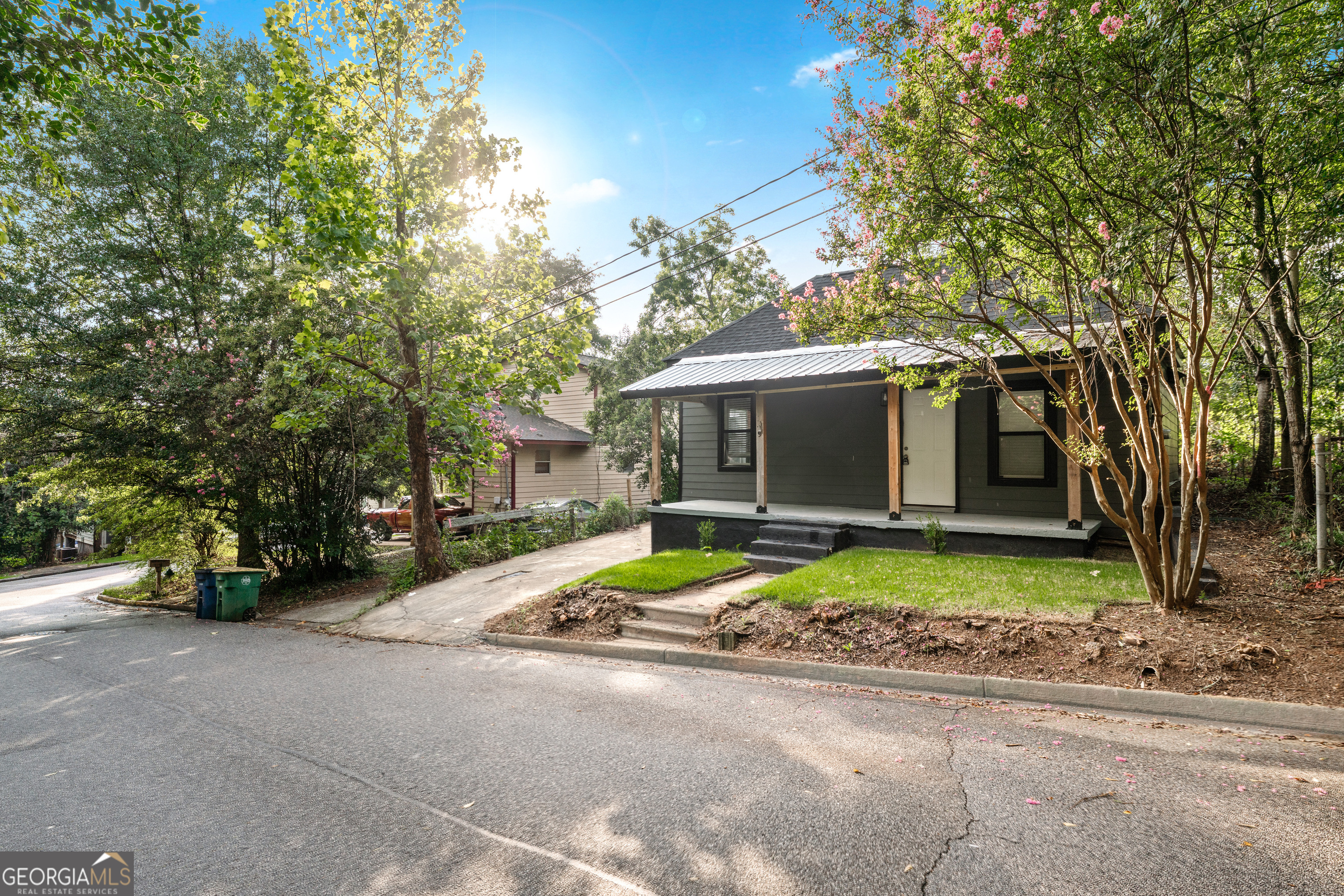 a view of a house with a yard and large tree
