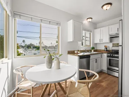 a kitchen with a table chairs a stove a microwave and cabinets