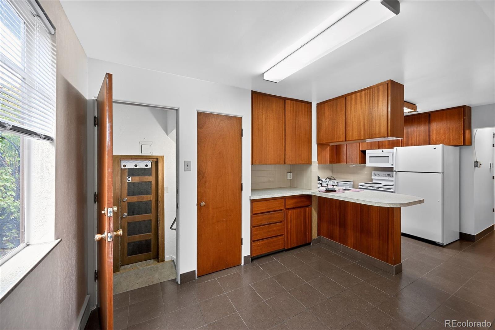 1955 West Virginia Avenue Denver, CO 80223 - Photo 12 of 36 a kitchen with stainless steel appliances granite countertop a refrigerator and a stove top oven