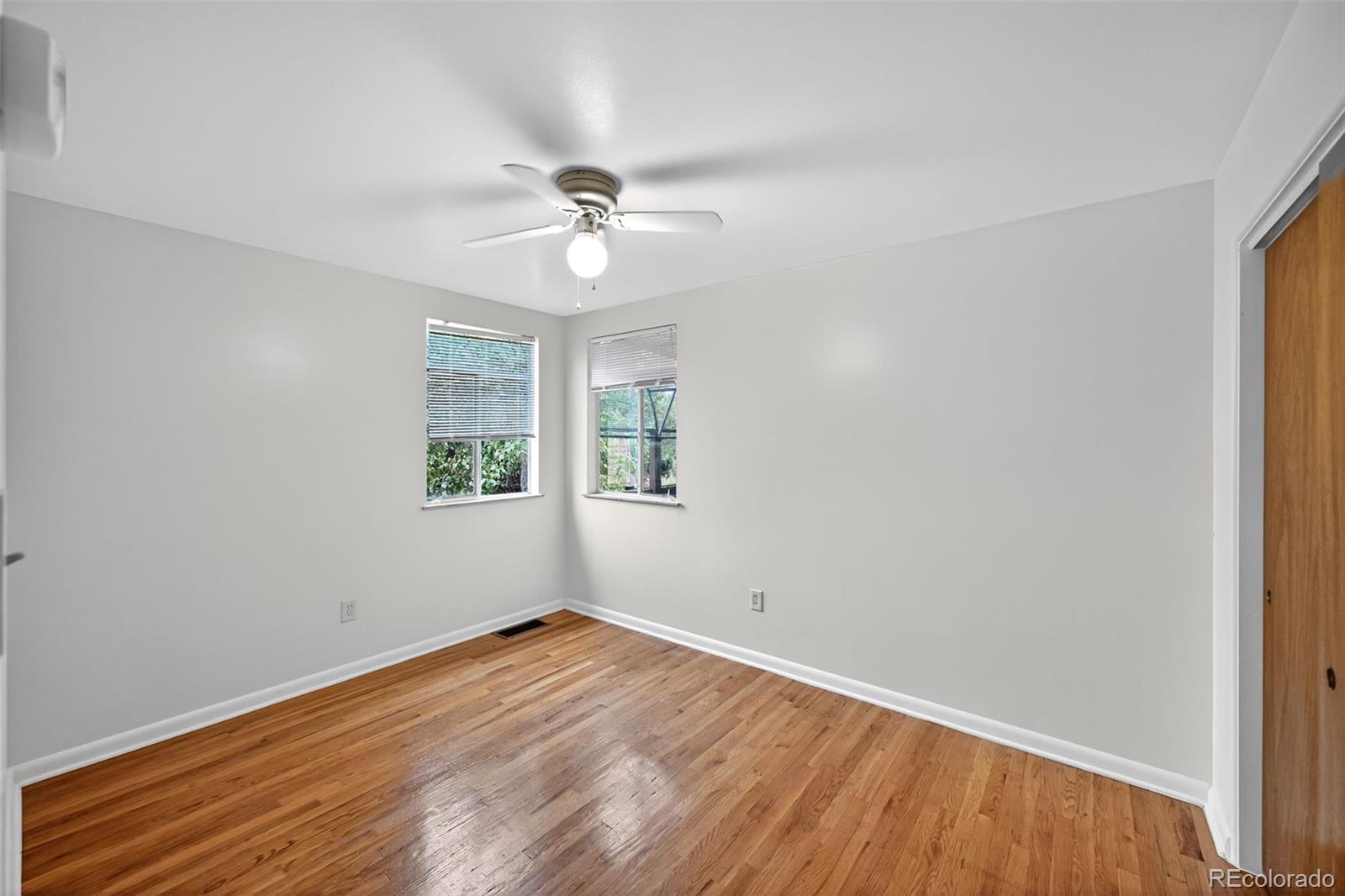 1955 West Virginia Avenue Denver, CO 80223 - Photo 17 of 36 a view of empty room with wooden floor and fan