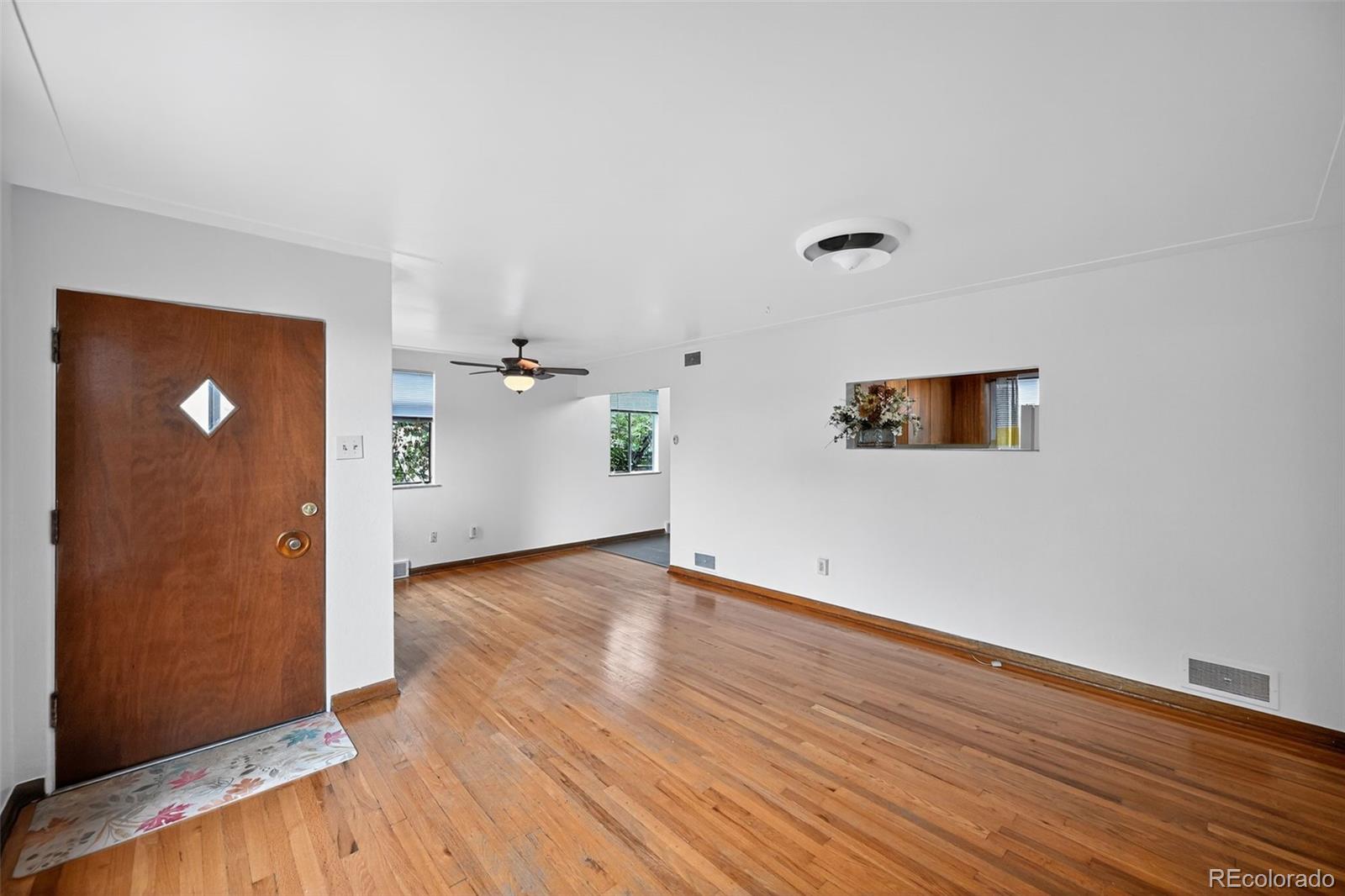 1955 West Virginia Avenue Denver, CO 80223 - Photo 3 of 36 an empty room with wooden floor and windows