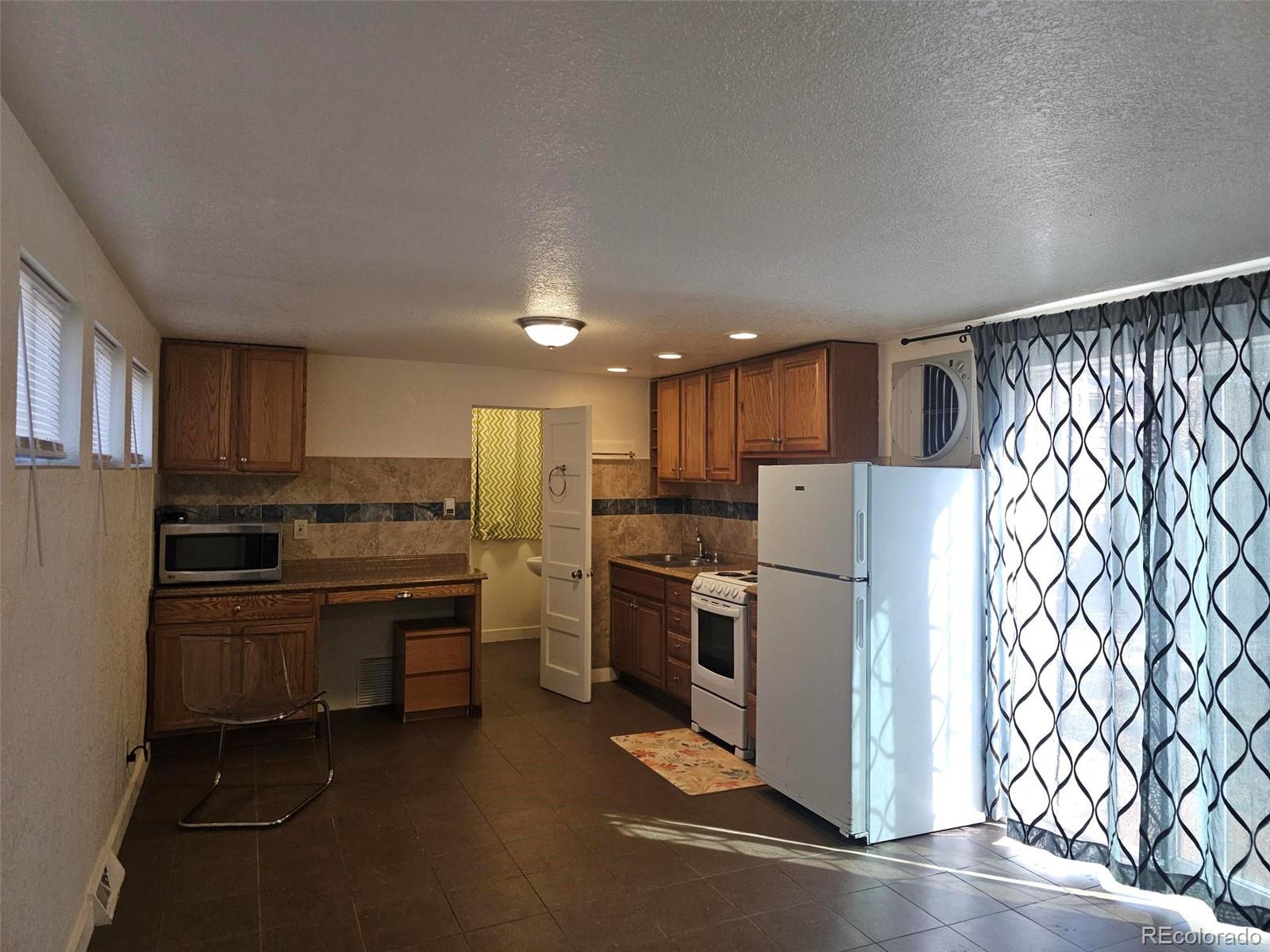 1955 West Virginia Avenue Denver, CO 80223 - Photo 33 of 36 a kitchen with stainless steel appliances a refrigerator and a stove top oven