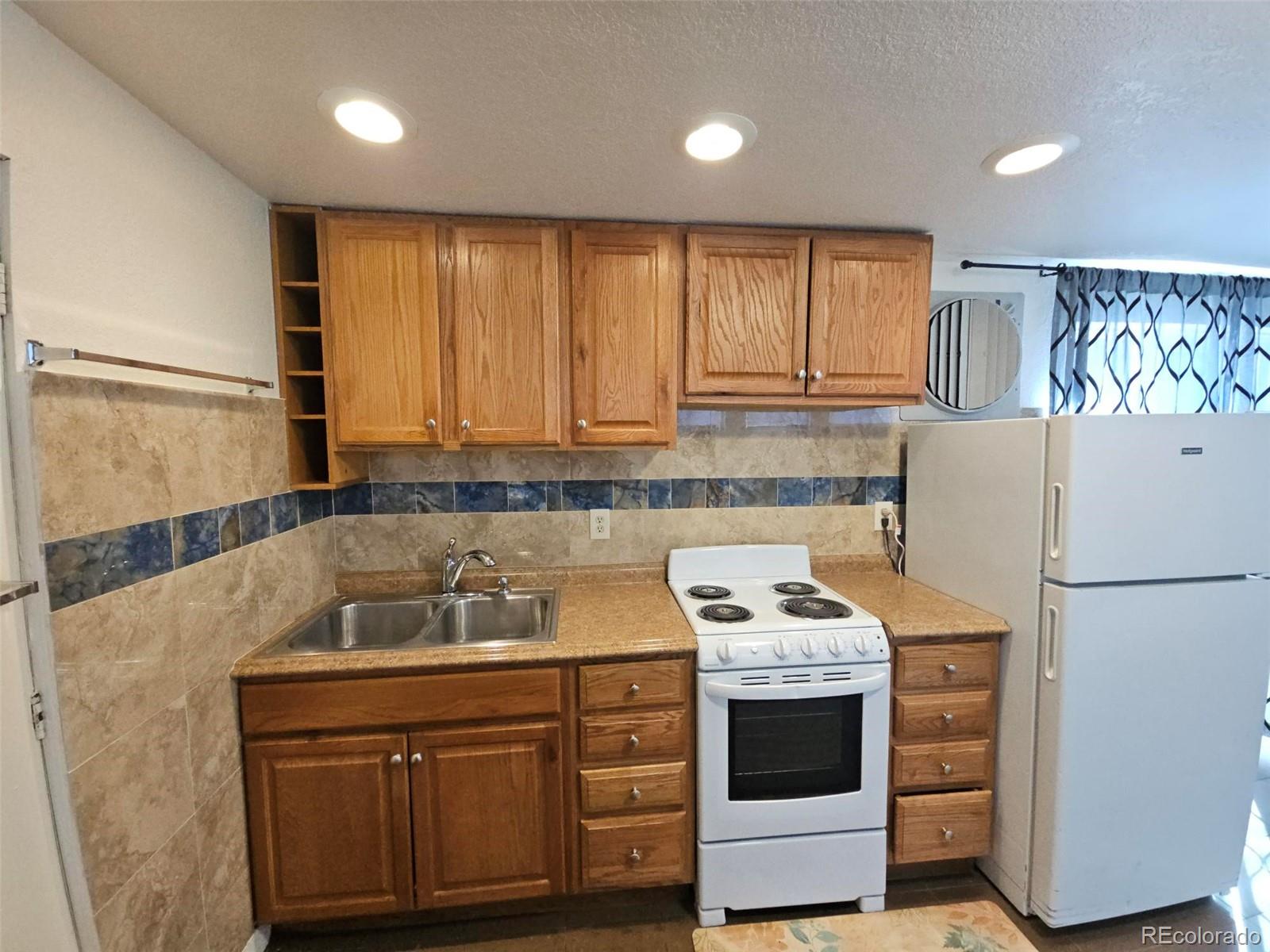 1955 West Virginia Avenue Denver, CO 80223 - Photo 34 of 36 a kitchen with a stove a refrigerator and a sink