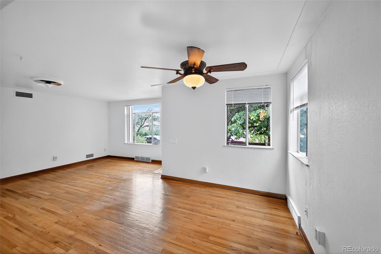 1955 West Virginia Avenue Denver, CO 80223 - Photo 5 of 36 a view of an empty room with window and wooden floor