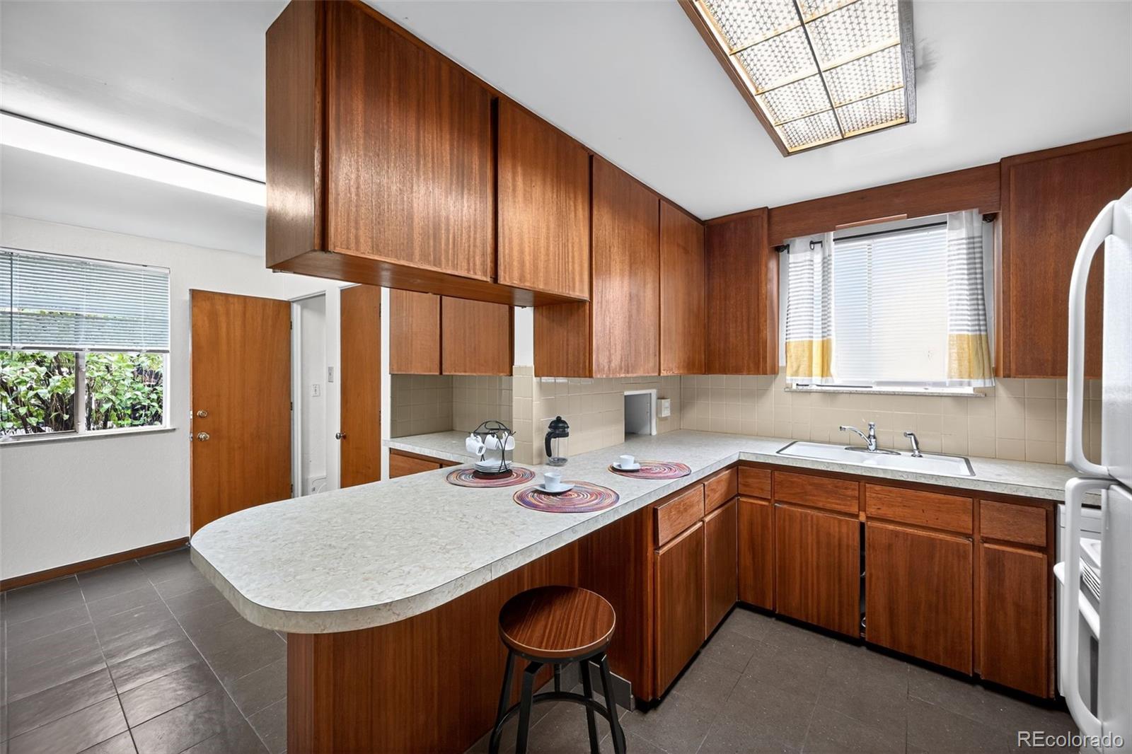 1955 West Virginia Avenue Denver, CO 80223 - Photo 9 of 36 a kitchen with stainless steel appliances a sink a stove and a refrigerator