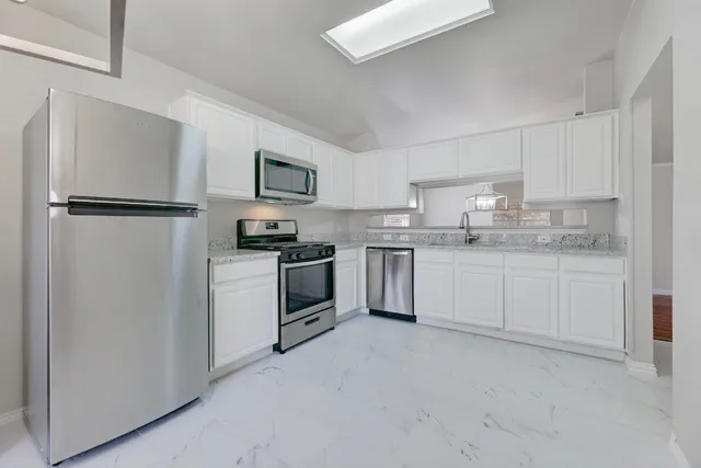 a kitchen with stainless steel appliances granite countertop a stove a refrigerator and a sink