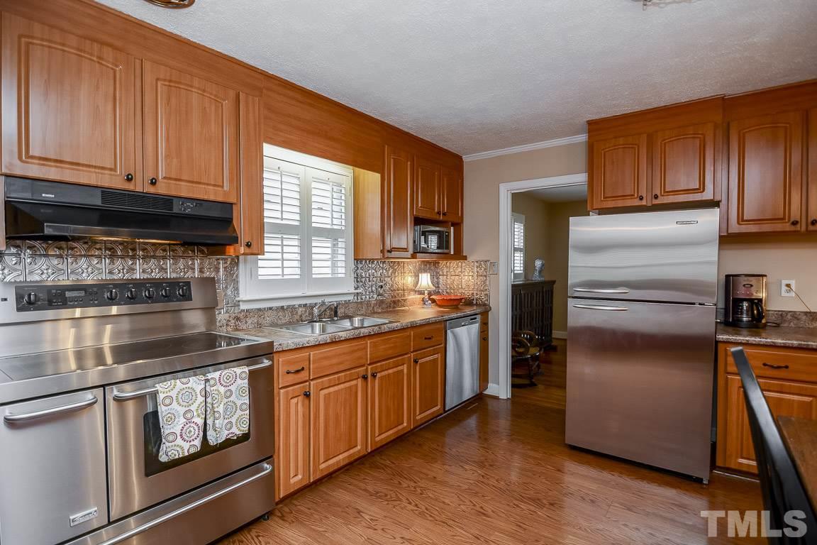 3604 Cranston Road Garner, NC 27529 - Photo 14 of 25 a kitchen with granite countertop stainless steel appliances and wooden cabinets