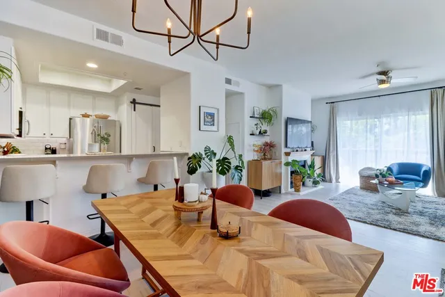 a living room with furniture kitchen view and a window
