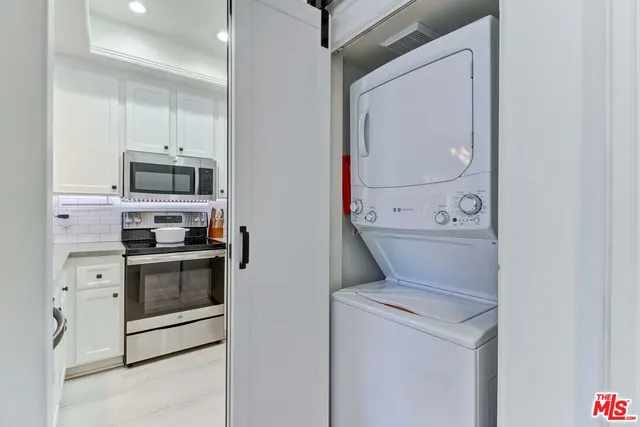 a view of washer and dryer with kitchen in the background