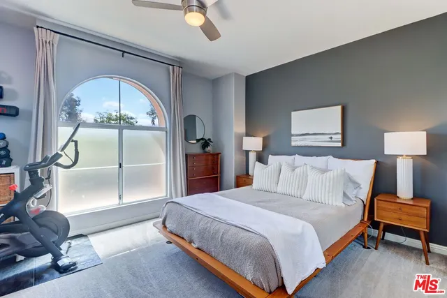 a spacious bedroom with a bed and a chandelier