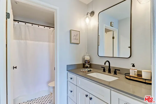 a bathroom with a granite countertop sink and a mirror