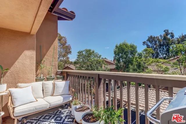 a balcony with wooden floor and outdoor seating