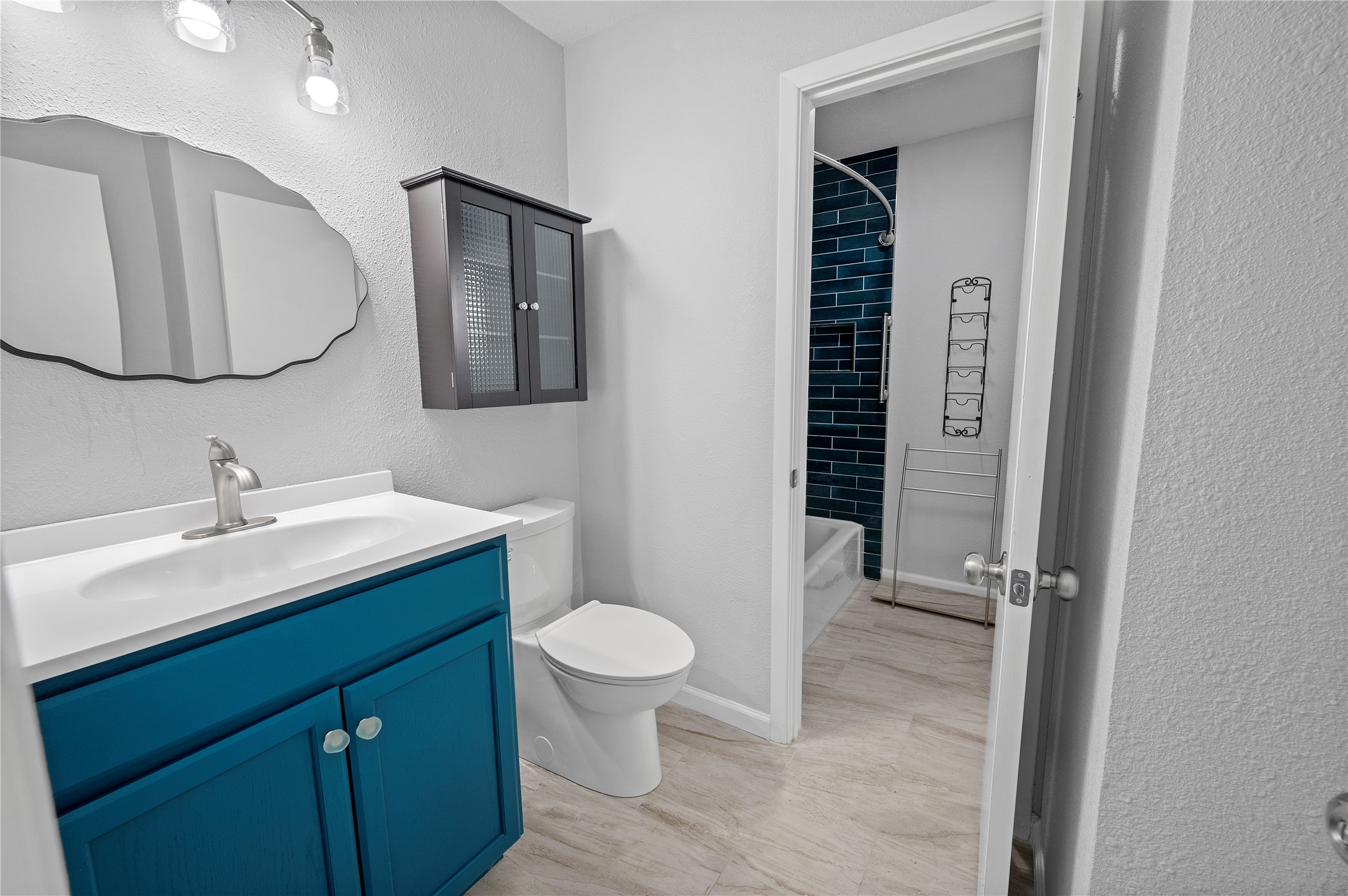 11301 Jollyville Road, Unit B3 Austin, TX 78759 - Photo 20 of 23 Full bath featuring a textured wall, vanity, and bathing tub / shower combination