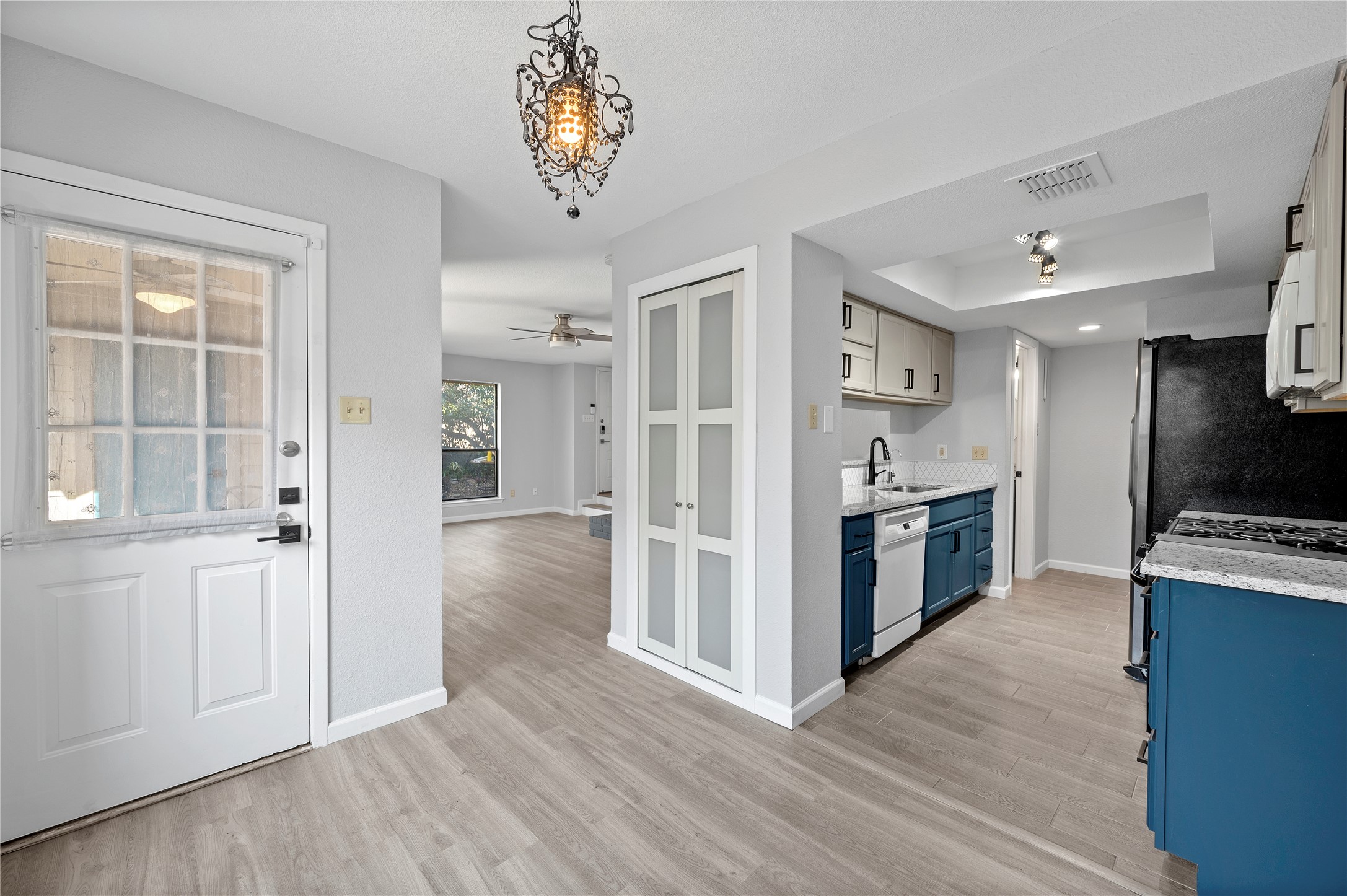 11301 Jollyville Road, Unit B3 Austin, TX 78759 - Photo 5 of 23 Kitchen featuring blue cabinetry, pendant lighting, light wood-style flooring, and a raised ceiling