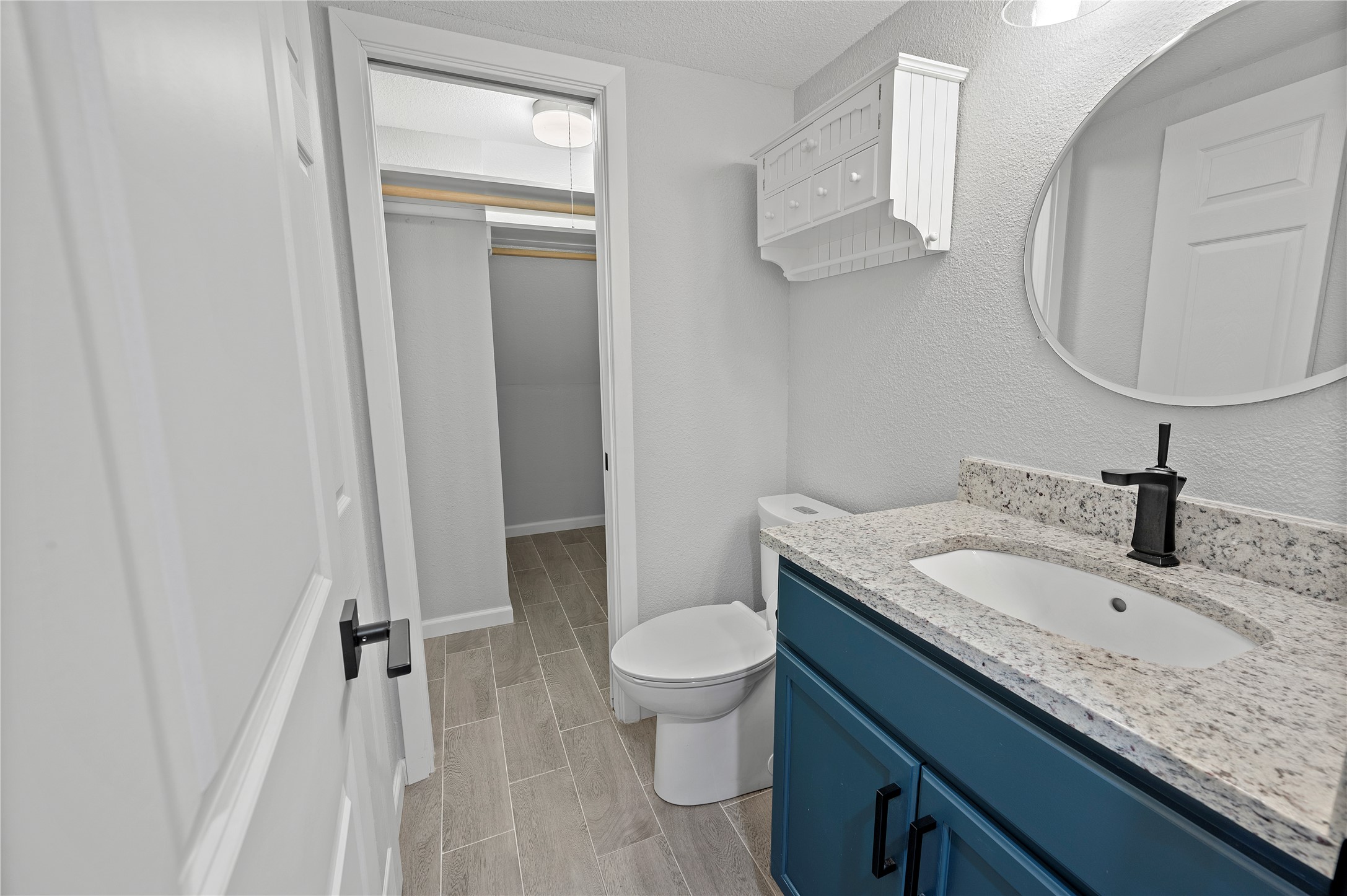11301 Jollyville Road, Unit B3 Austin, TX 78759 - Photo 6 of 23 Bathroom featuring vanity, a textured ceiling, wood tiled floors, and a textured wall