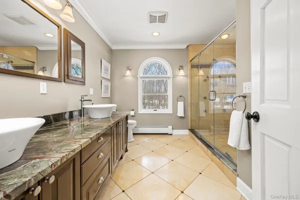 a bathroom with a granite countertop sink a mirror and a bath tub