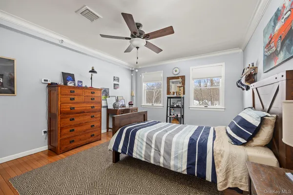 a spacious bedroom with a bed and ceiling fan