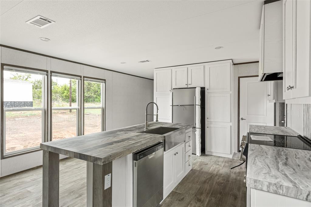 4510 Tennessee Trail Granbury, TX 76048 - Photo 12 of 25 a kitchen with granite countertop a refrigerator and a sink