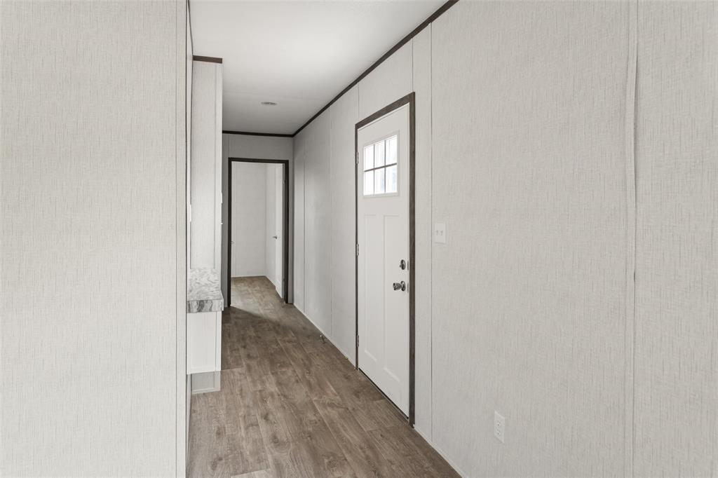 4510 Tennessee Trail Granbury, TX 76048 - Photo 5 of 25 a view of a hallway with wooden floor and a bathroom