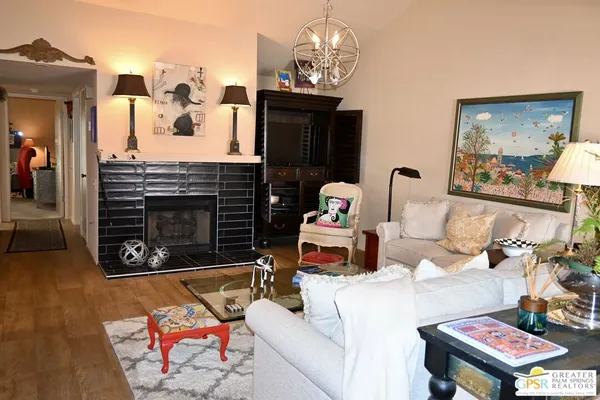 a living room with furniture a chandelier and a fireplace