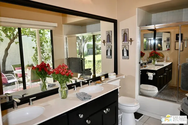 a en suite bathroom with a double vanity sink and a mirror