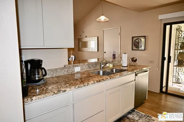 a kitchen with stainless steel appliances granite countertop white cabinets and a granite counter tops