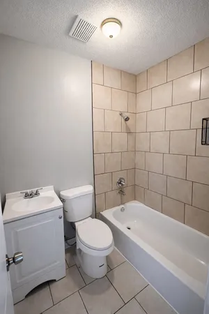 a bathroom with a toilet a sink a mirror and bathtub