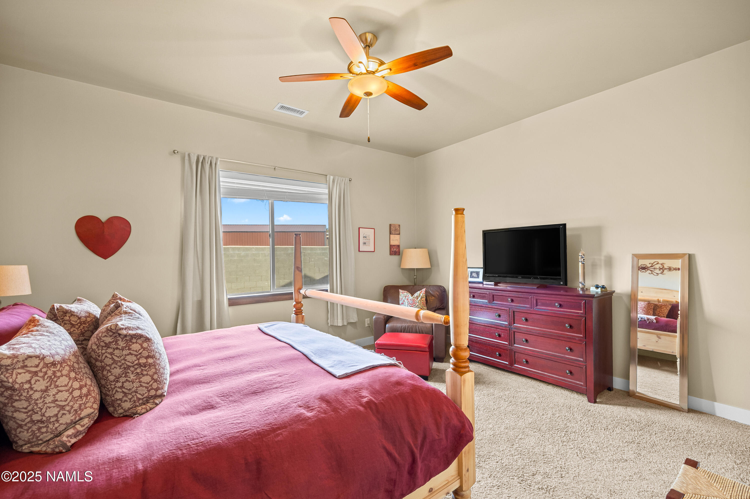 12030 Hydrus Road Bellemont, AZ 86015 - Photo 12 of 30 a bedroom with a bed and dresser with mirror