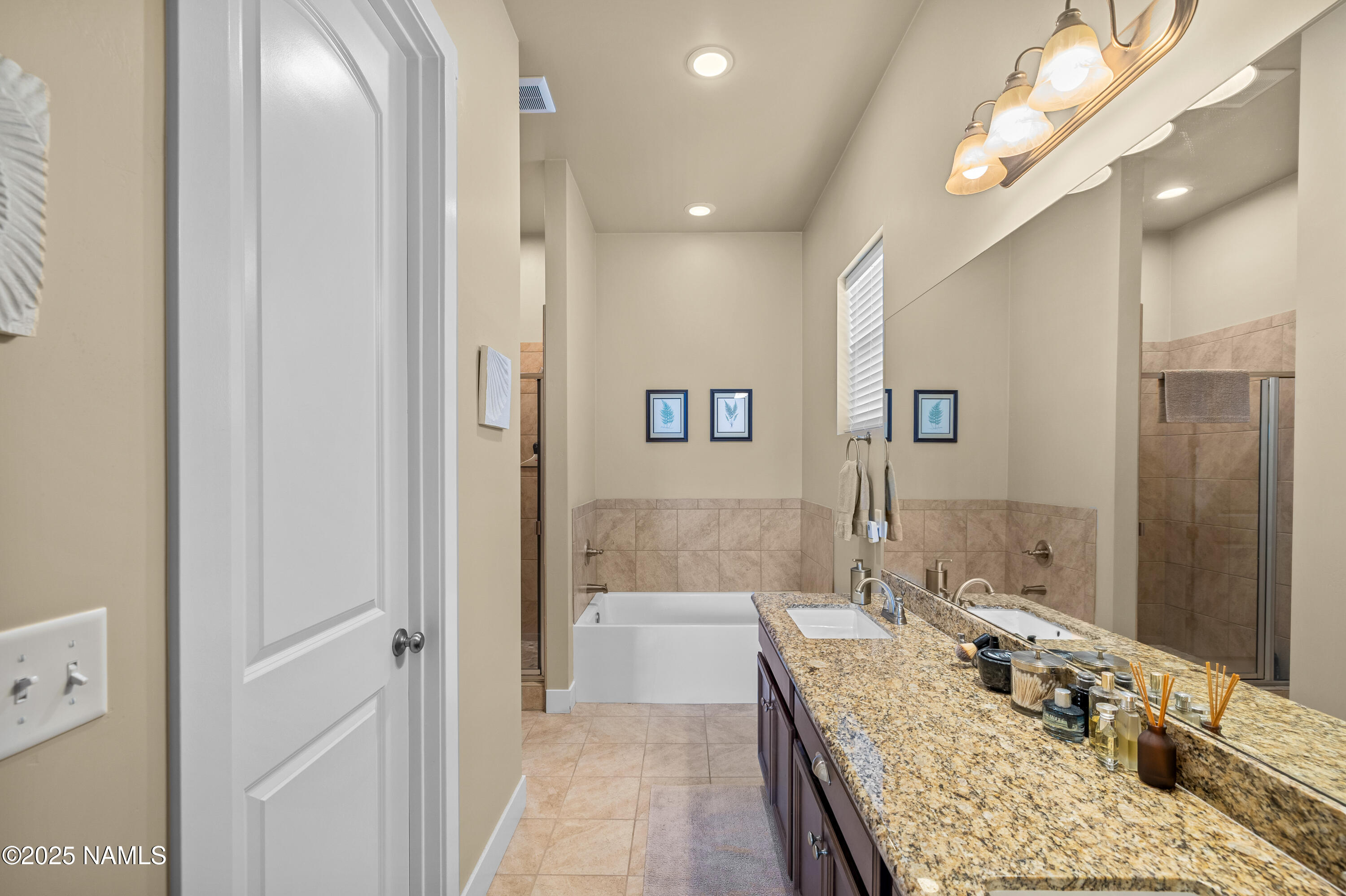 12030 Hydrus Road Bellemont, AZ 86015 - Photo 15 of 30 a bathroom with a granite countertop sink a shower and a mirror