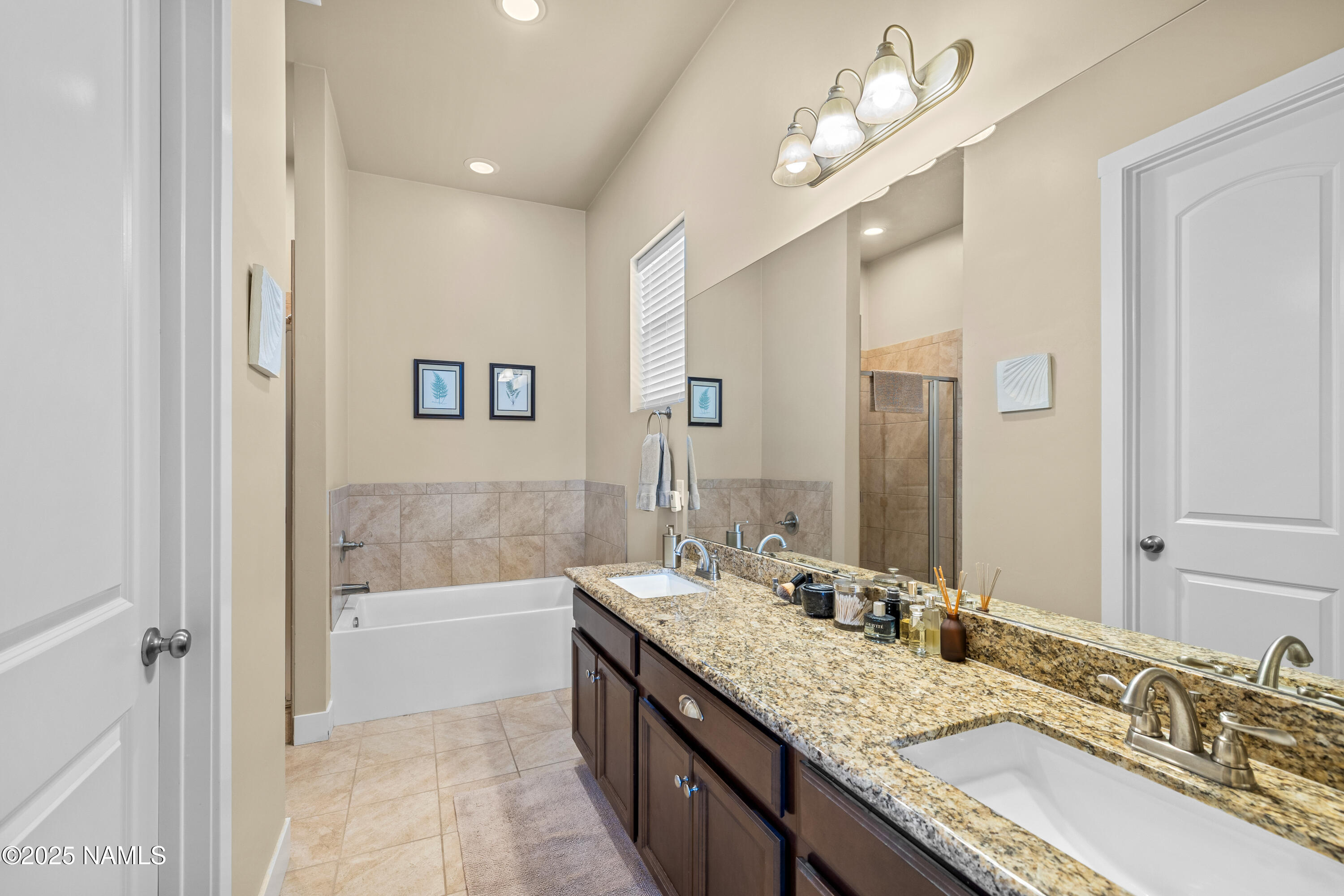 12030 Hydrus Road Bellemont, AZ 86015 - Photo 16 of 30 a bathroom with a granite countertop double vanity sink a mirror and a bathtub