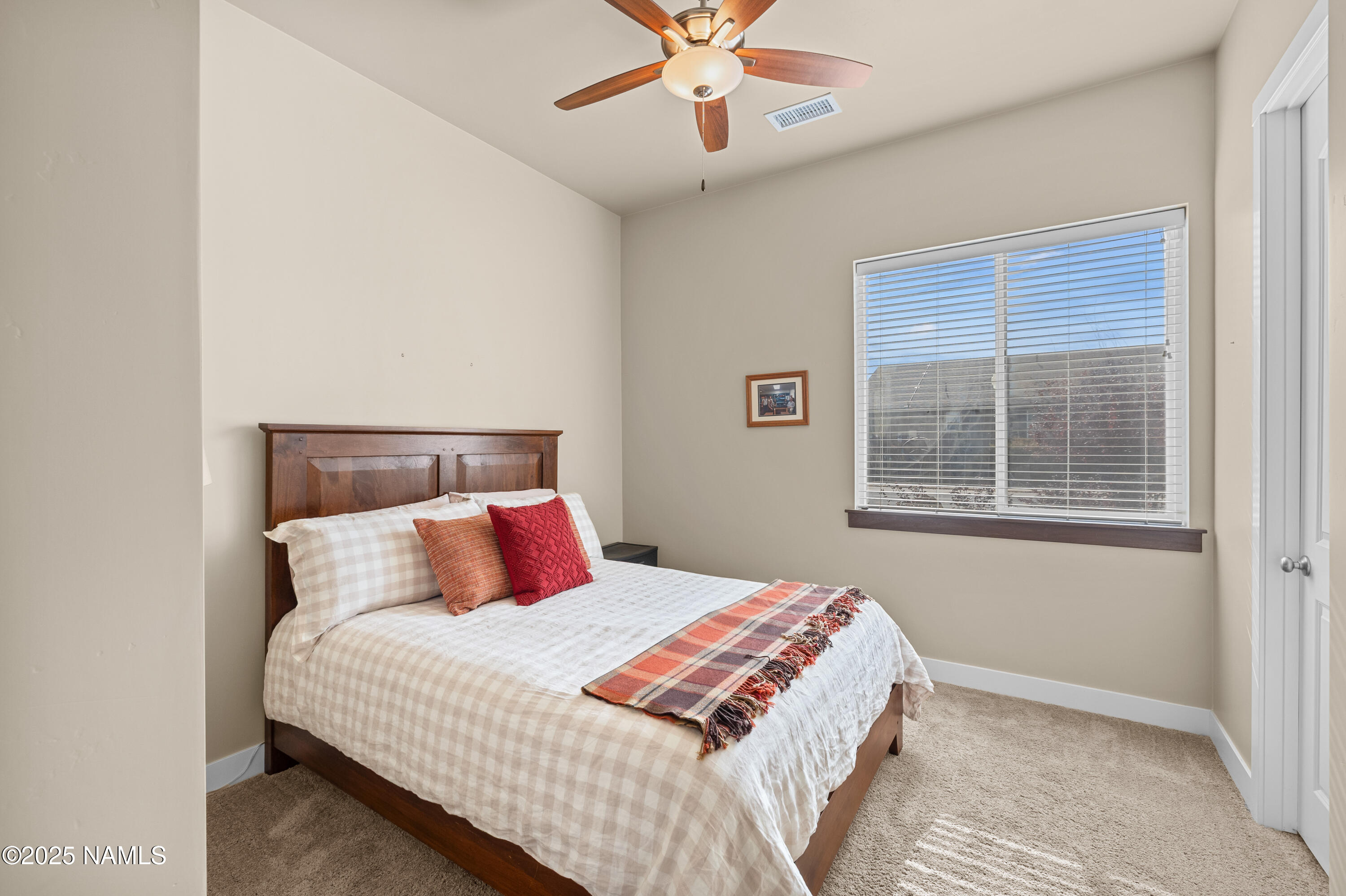 12030 Hydrus Road Bellemont, AZ 86015 - Photo 17 of 30 a bedroom with a large bed and a chandelier