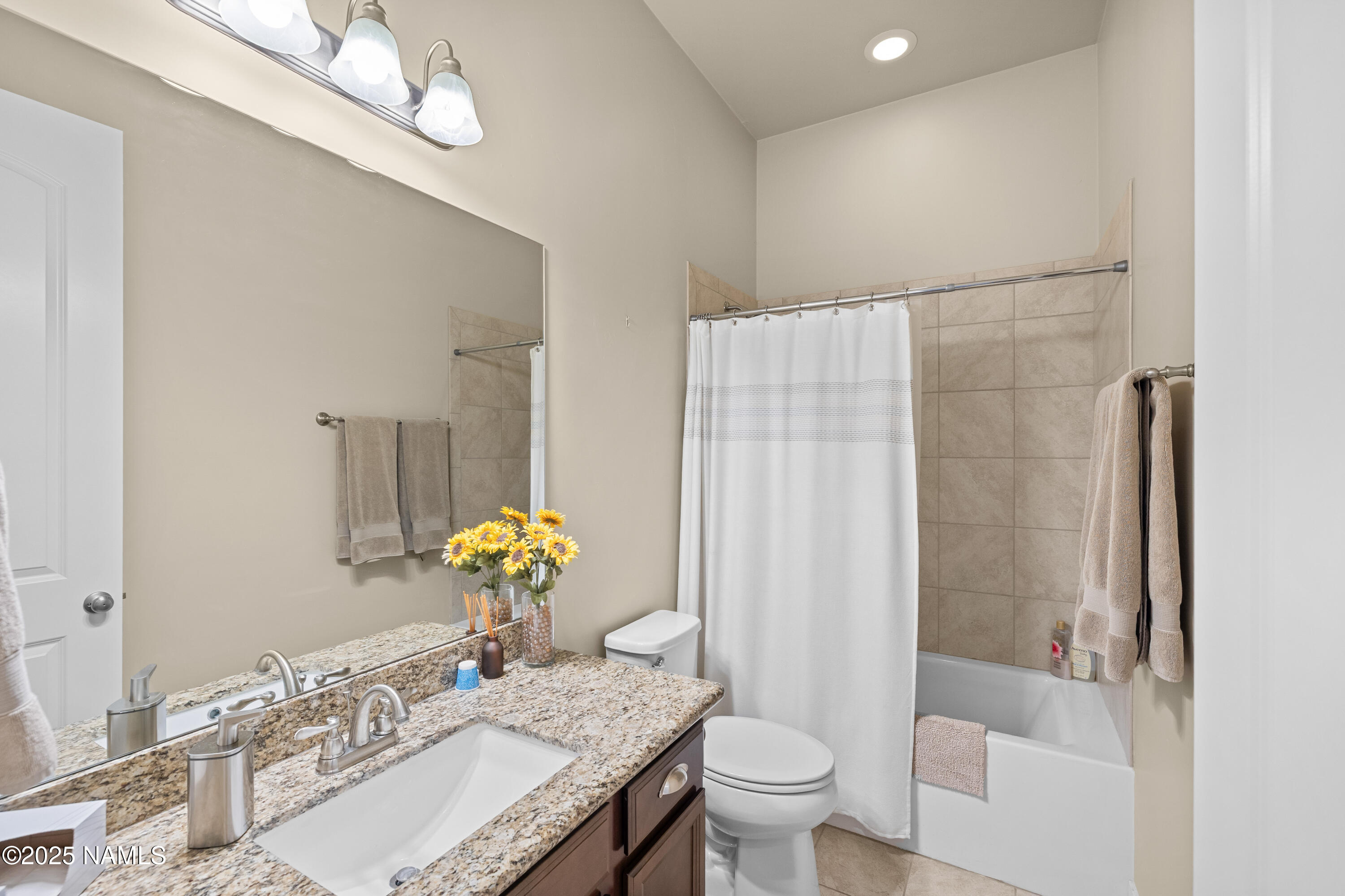 12030 Hydrus Road Bellemont, AZ 86015 - Photo 22 of 30 a bathroom with a granite countertop sink a toilet and shower