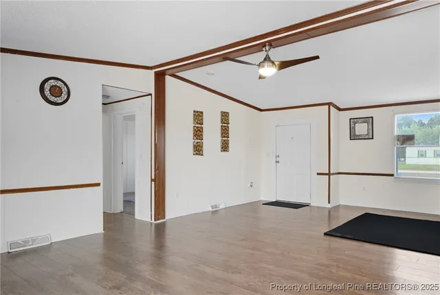 a view of empty room with cabinet and fan