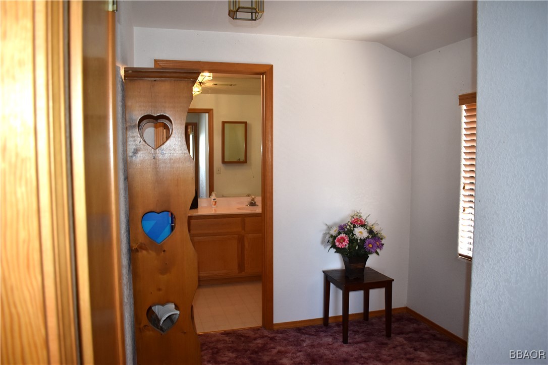 442 Inyo Avenue Sugarloaf, CA 92386 - Photo 17 of 36 a vase of flowers sitting on a table with a mirror