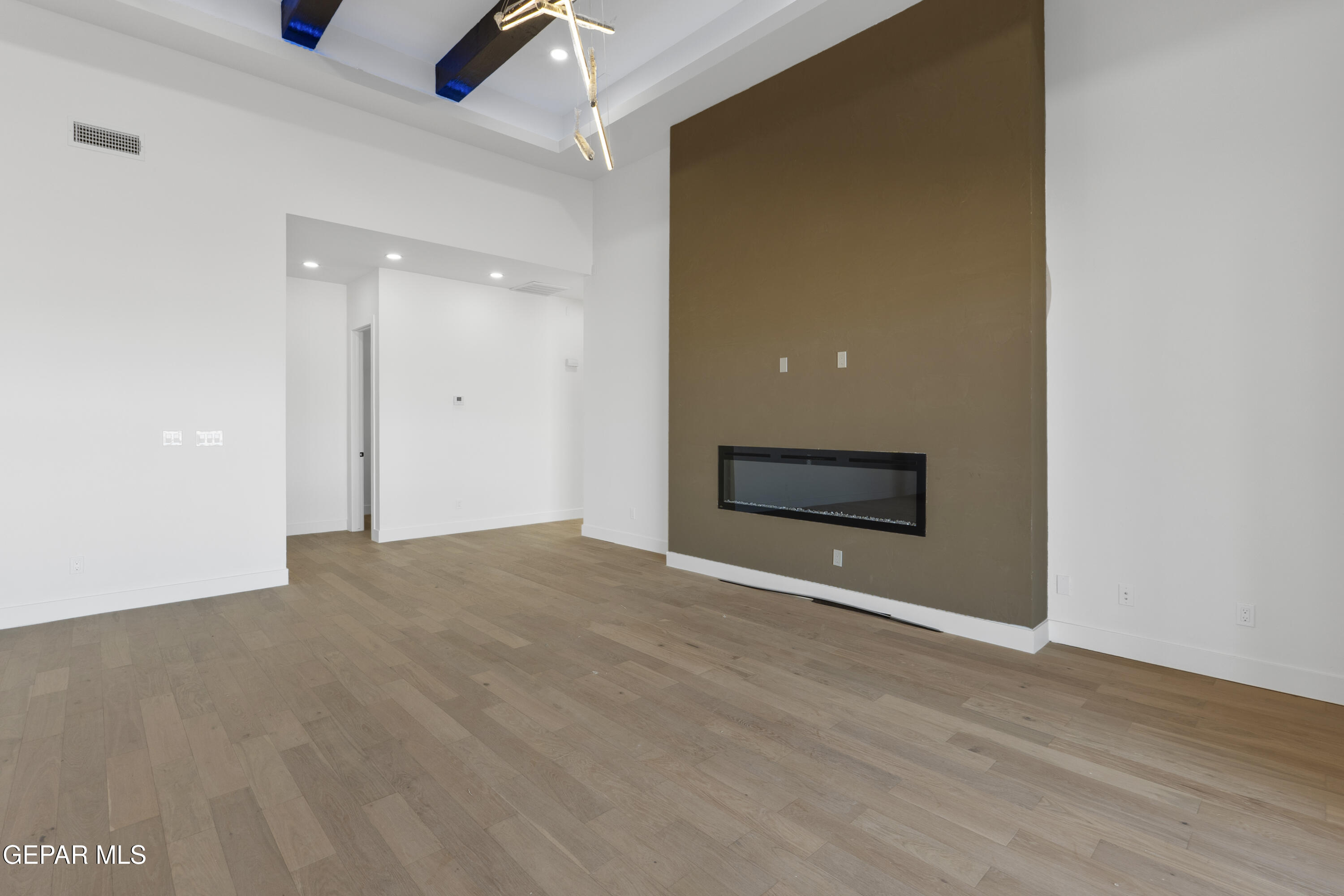 5659 Rio Bonito Circle El Paso, TX 79932 - Photo 13 of 55 a view of an empty room with wooden floor and a ceiling fan