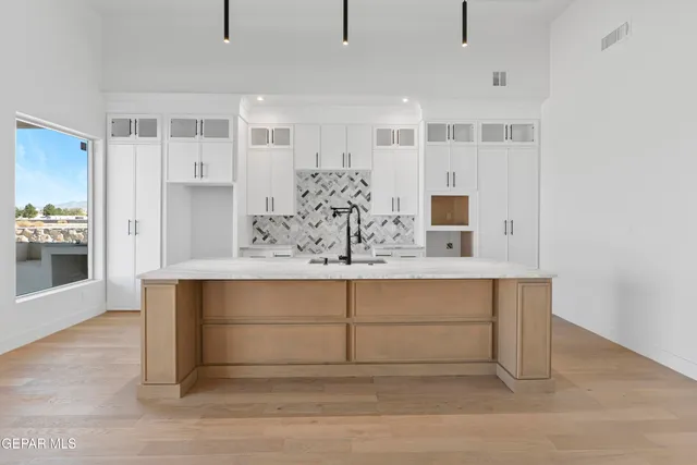 a kitchen with granite countertop a sink and a wooden floor