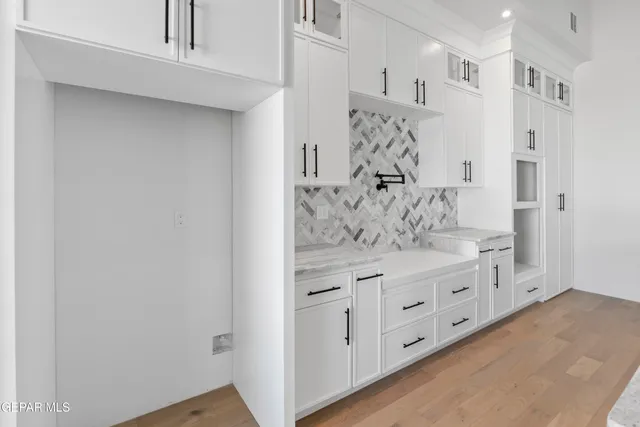 a kitchen with white cabinets and sink