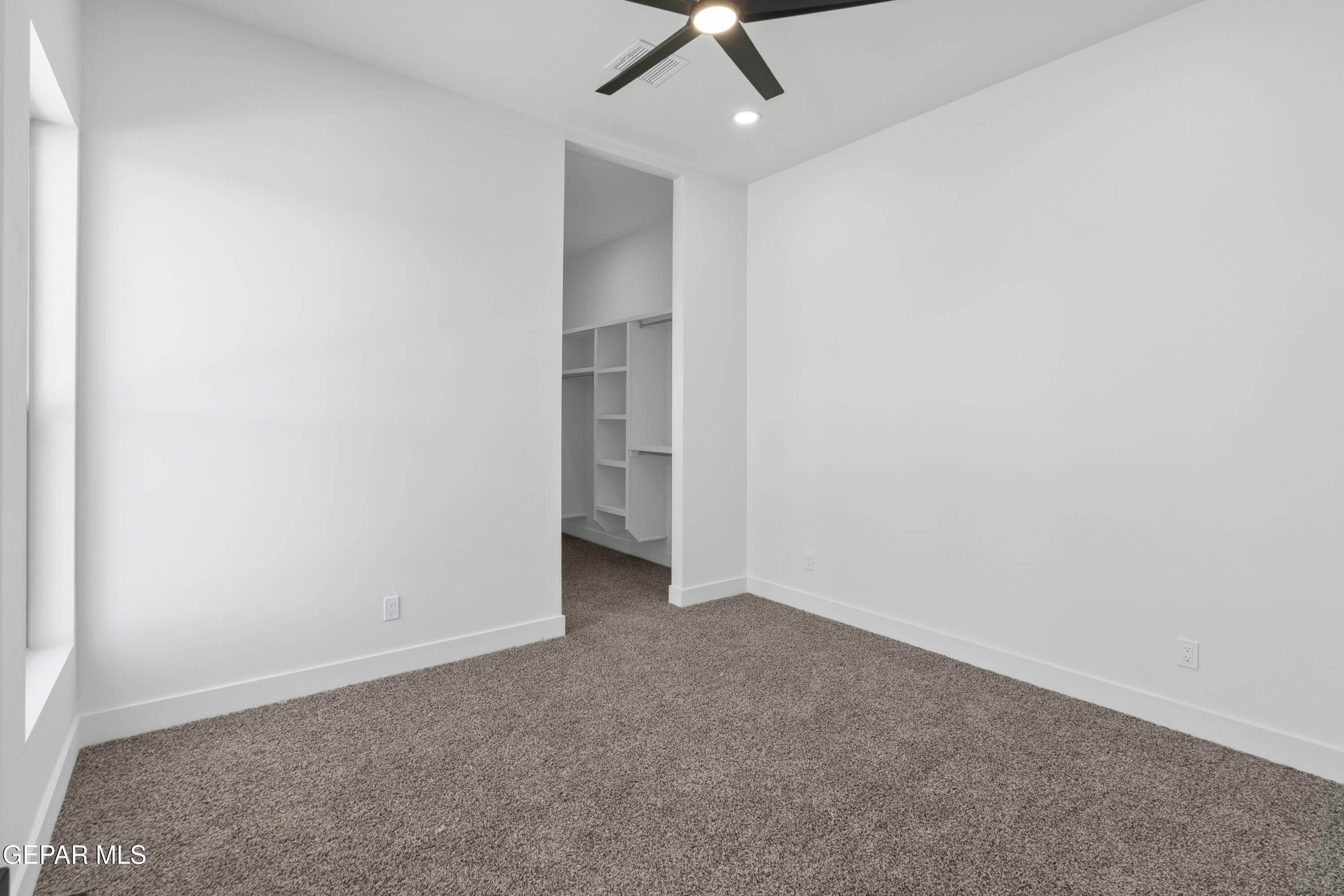5659 Rio Bonito Circle El Paso, TX 79932 - Photo 35 of 55 an empty room with a ceiling fan and carpet