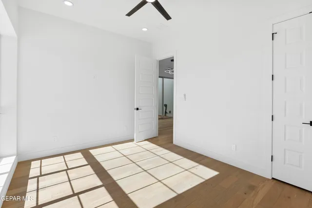 an empty room with windows and fireplace