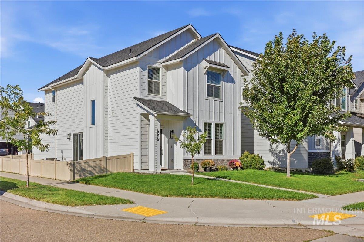 696 East Springloyd Street Meridian, ID 83642 - Photo 1 of 37 White vertical and horizontal siding exterior, stone accents, black shingle roof, paved sidewalk, and green lawn