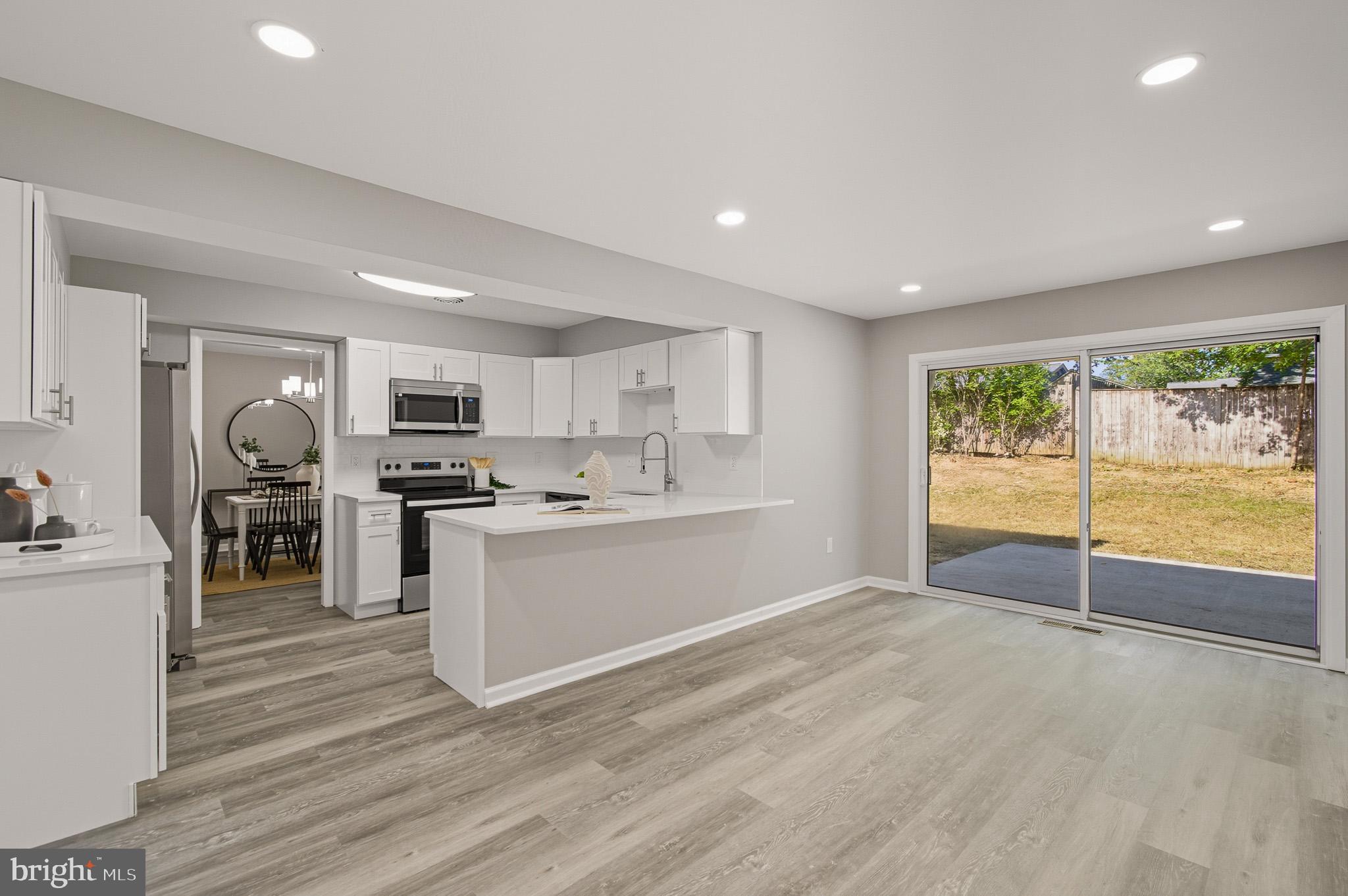 12414 Sandal Lane Bowie, MD 20715 - Photo 11 of 46 a large white kitchen with stainless steel appliances granite countertop a stove and a refrigerator