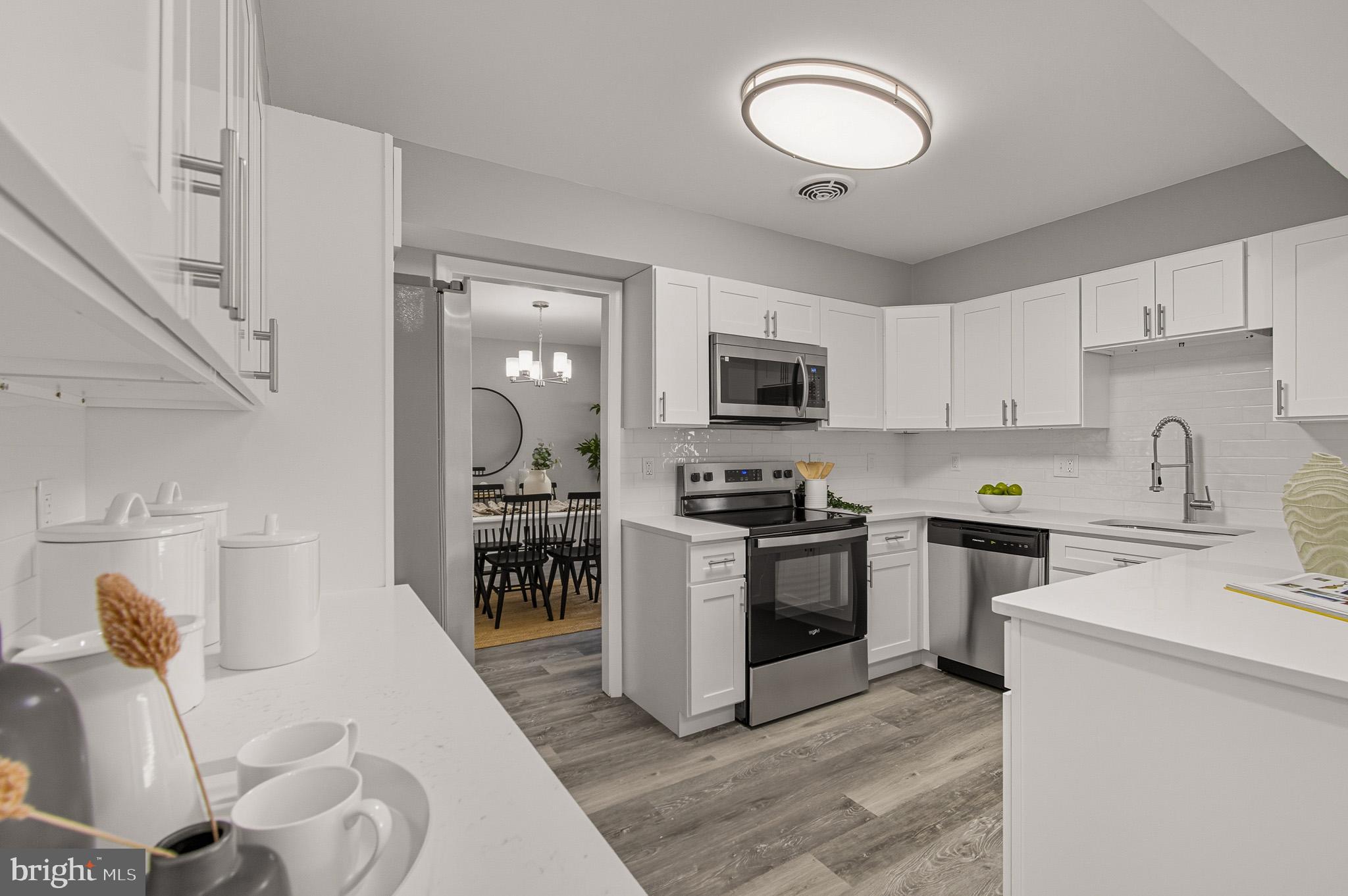 12414 Sandal Lane Bowie, MD 20715 - Photo 12 of 46 a kitchen with a sink a stove and cabinets