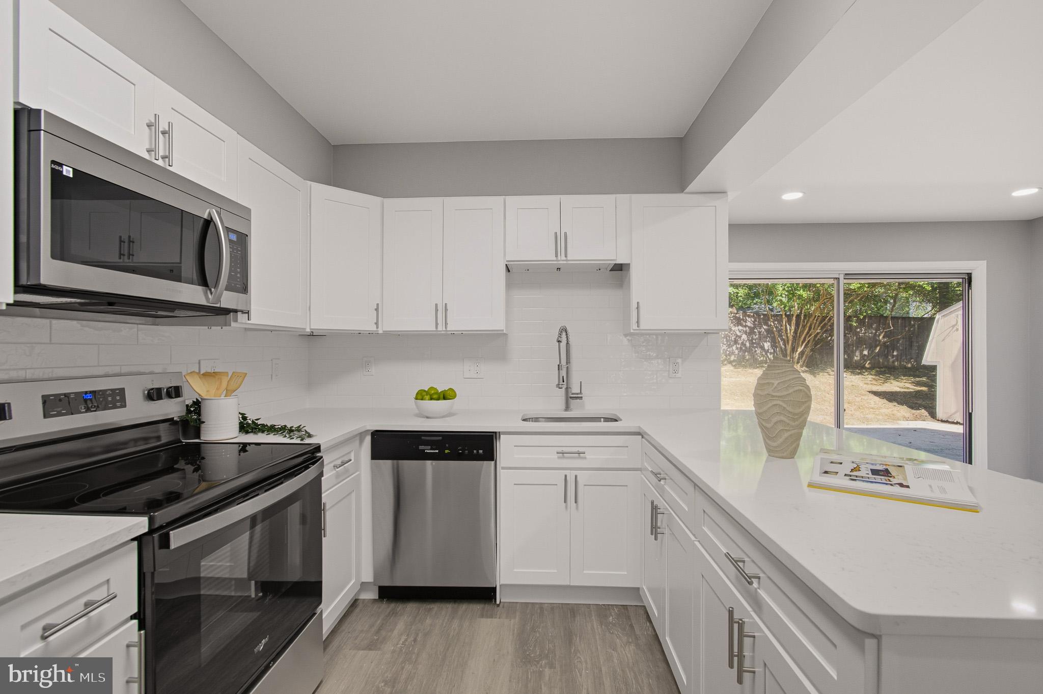 12414 Sandal Lane Bowie, MD 20715 - Photo 13 of 46 a kitchen with a sink stove and microwave