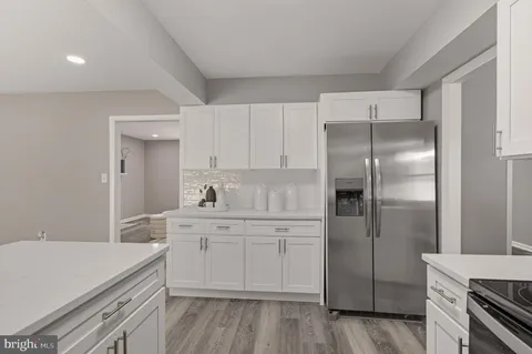 a kitchen with a sink cabinets stainless steel appliances and a window