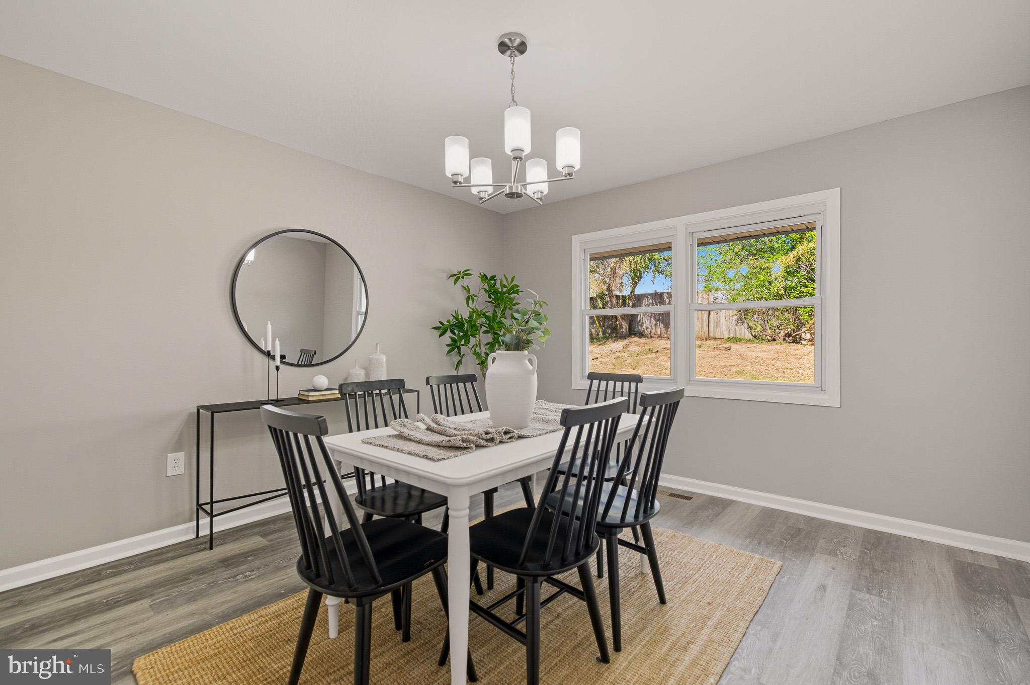 12414 Sandal Lane Bowie, MD 20715 - Photo 21 of 46 a view of a dining room with furniture a chandelier and wooden floor