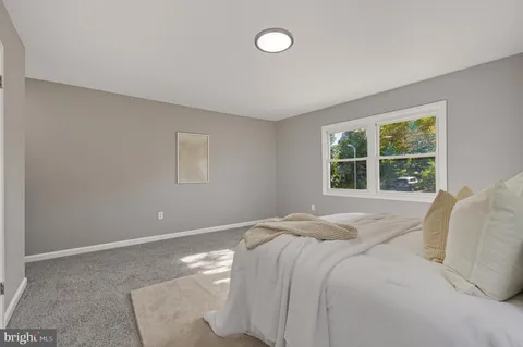 a bed sitting in a bedroom next to a window