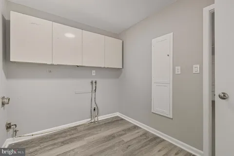 an empty room with wooden floor and cabinets
