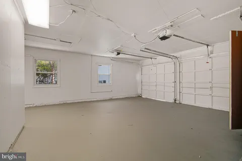 en empty room with white walls and ceiling fan