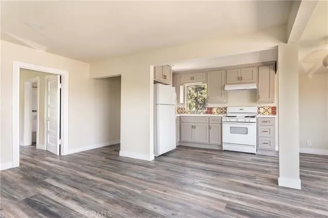 an empty room with wooden floor and outdoor view